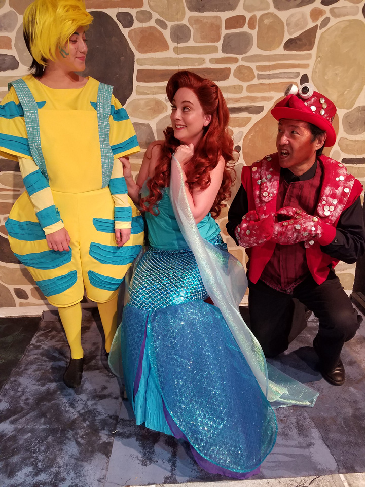 Ariel’s friends, Flounder (Sadie Fisher) and Sebastian (Roy Okida), tell Ariel (Lyndsay Palmer) how wonderful life is “Under the Sea”
